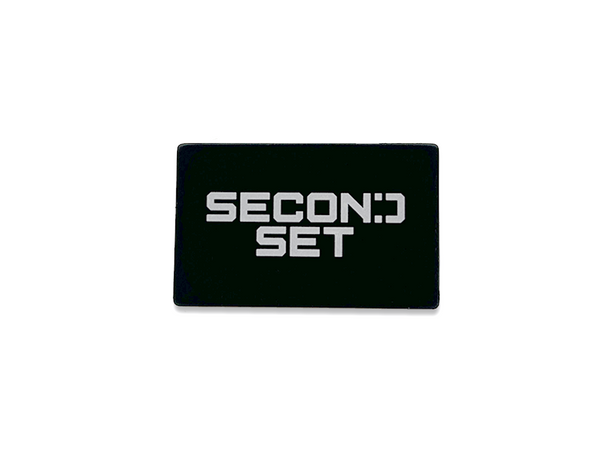 A black rectangular magnet featuring the white 