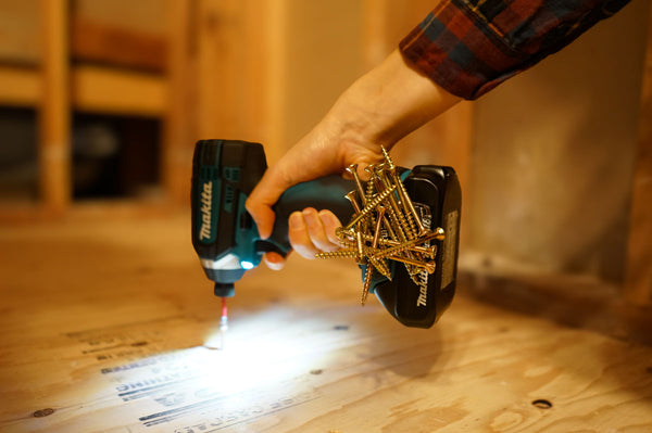 A Makita drill equipped with a Second Set magnet holding multiple screws, providing convenient access for construction tasks on a wooden surface.
